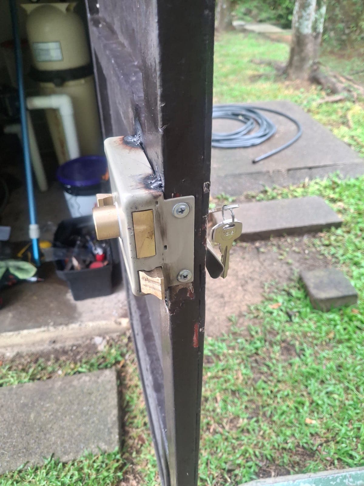 Soldadura y reparación de cerradura en portón metálico con llave, servicio de cerrajería industrial en Costa Rica